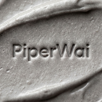 Close-up of a textured gray cream or gel with the brand name 'PiperWai' embossed in the center.