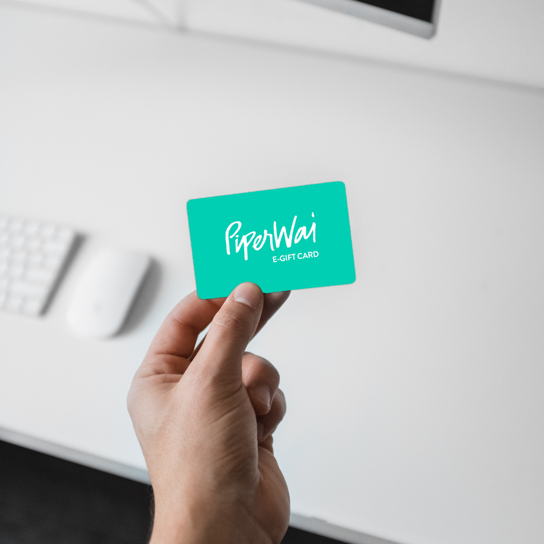 A hand holding a digital gift card from PiperWai Natural Deodorant with a green and white color scheme.