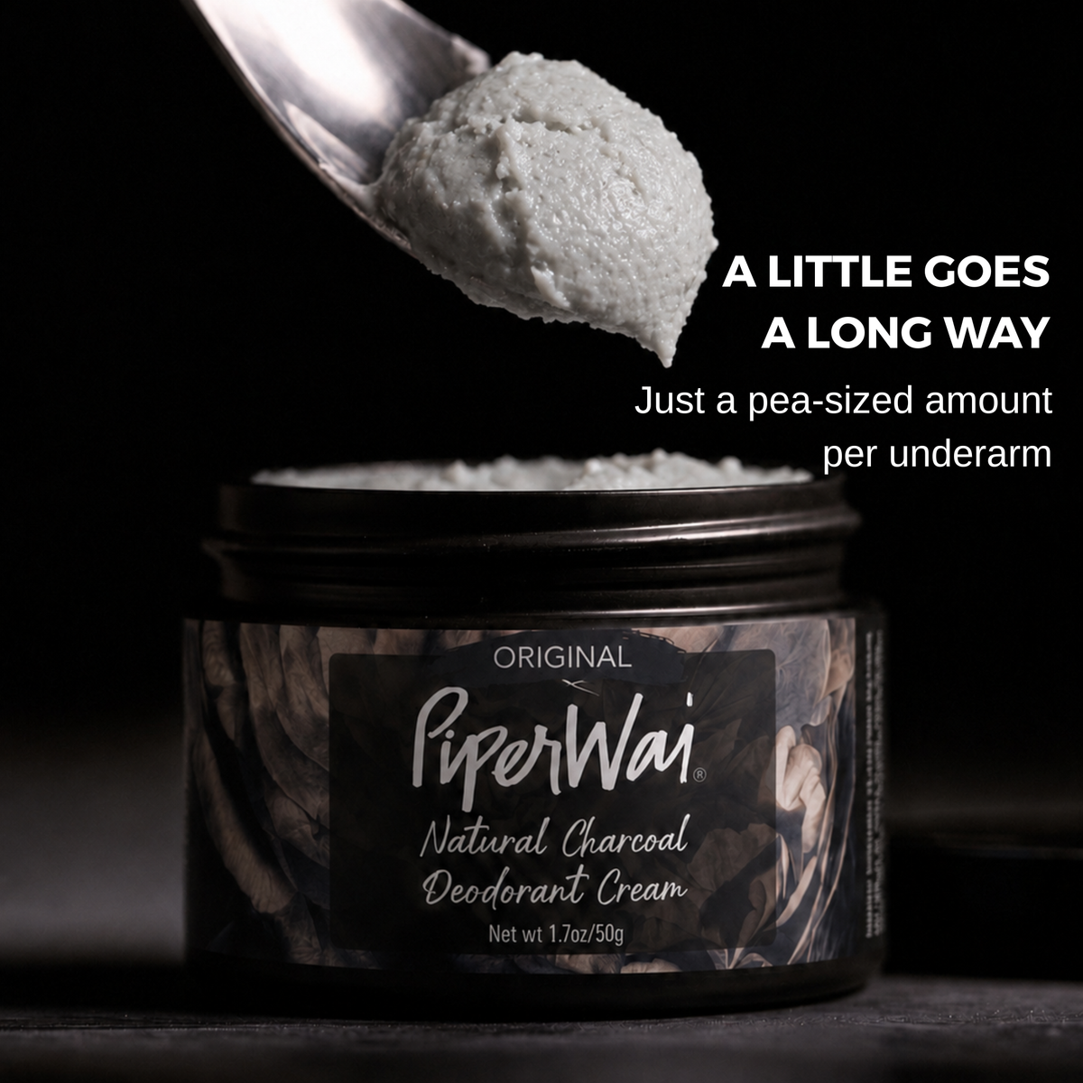 A jar of PiperWai Natural Charcoal Deodorant Cream with a spoonful of the light gray deodorant cream above it, set against a dark background with promotional text.