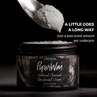 A jar of PiperWai Natural Charcoal Deodorant Cream with a spoonful of the light gray deodorant cream above it, set against a dark background with promotional text.